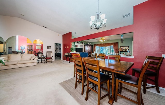 carpeted dining space with lofted ceiling and ceiling fan with notable chandelier