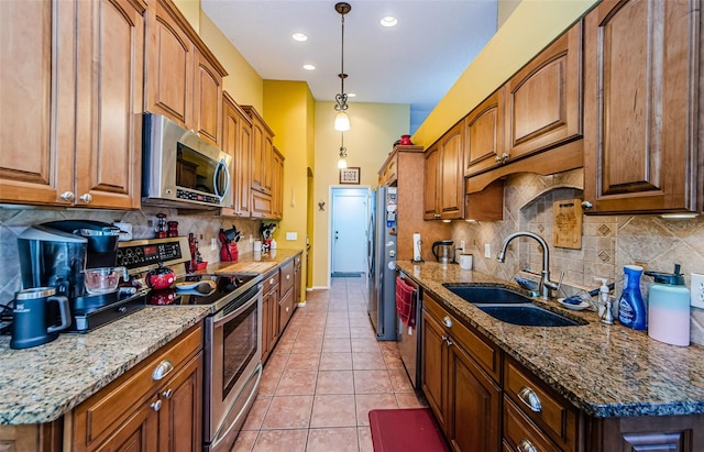 kitchen with sink, light tile patterned floors, appliances with stainless steel finishes, tasteful backsplash, and light stone countertops