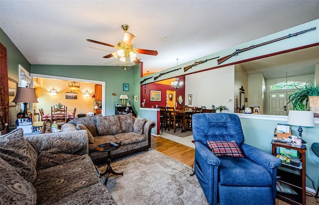 living room with hardwood / wood-style flooring, ceiling fan, lofted ceiling, and a textured ceiling