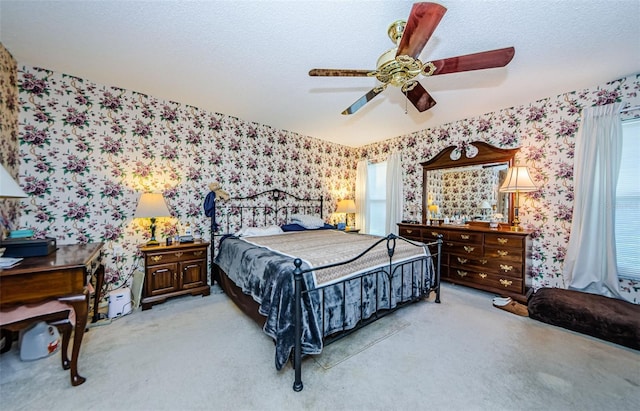 carpeted bedroom with ceiling fan and a textured ceiling