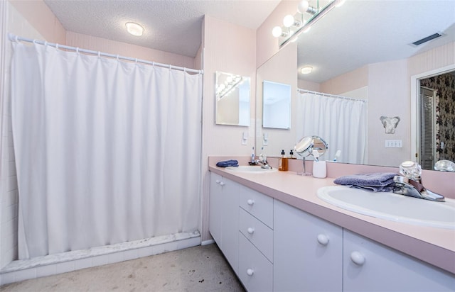 bathroom featuring vanity, curtained shower, and a textured ceiling