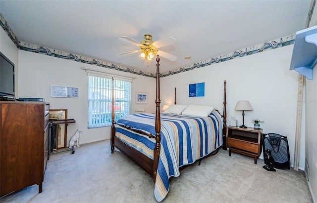 carpeted bedroom with ceiling fan and a textured ceiling