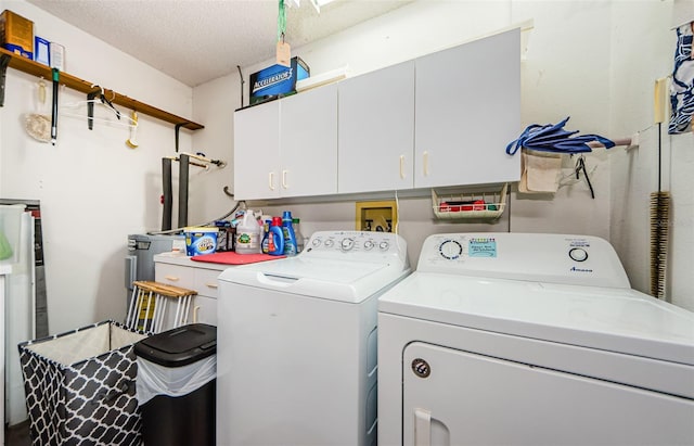 laundry area with cabinets, separate washer and dryer, and a textured ceiling