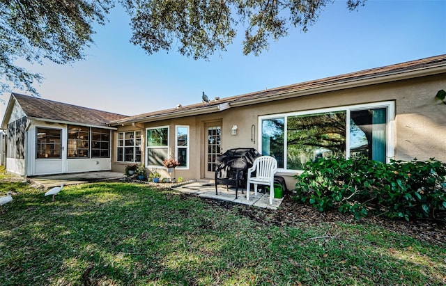 back of property featuring a sunroom, a yard, and a patio area