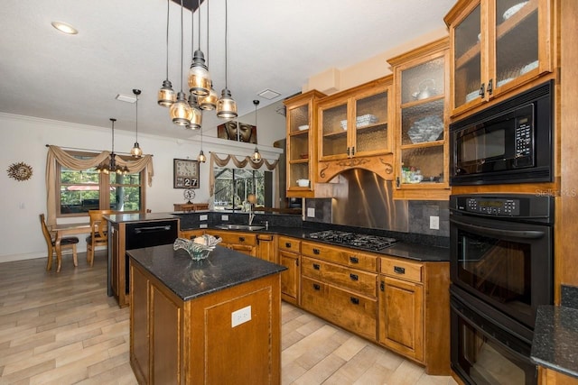 kitchen with kitchen peninsula, hanging light fixtures, ornamental molding, black appliances, and a center island