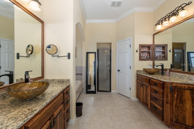 bathroom with vanity, tile patterned floors, crown molding, and a bath