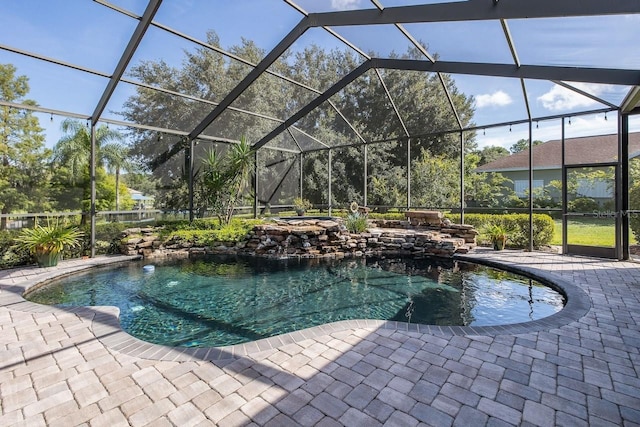 view of swimming pool featuring a lanai, pool water feature, and a patio