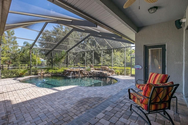 view of swimming pool featuring pool water feature, glass enclosure, and a patio area