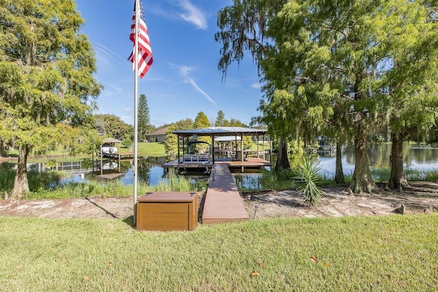 view of dock with a water view and a lawn