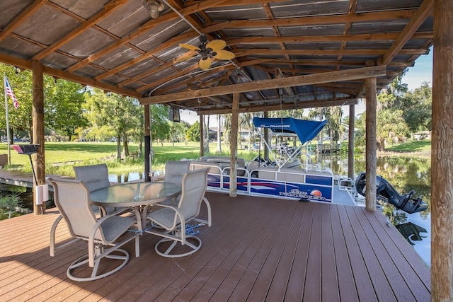 wooden terrace featuring a water view, ceiling fan, and a lawn