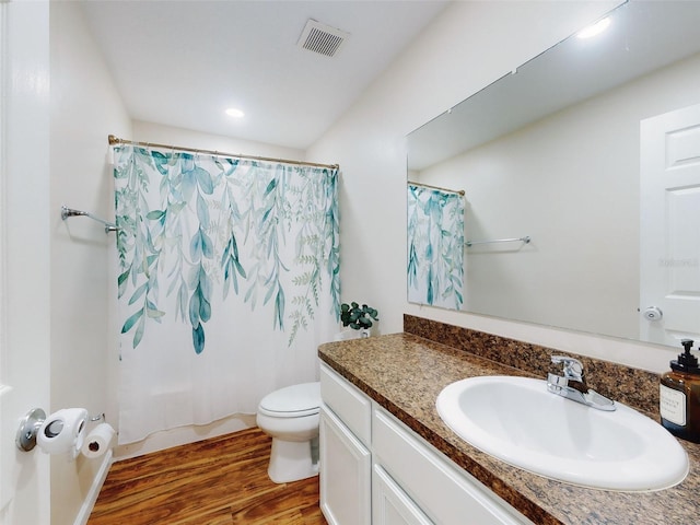 bathroom featuring wood-type flooring, toilet, and vanity