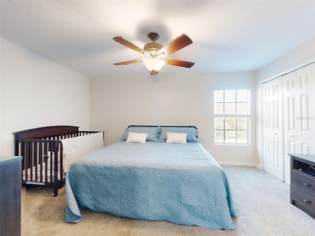 carpeted bedroom with ceiling fan and a closet