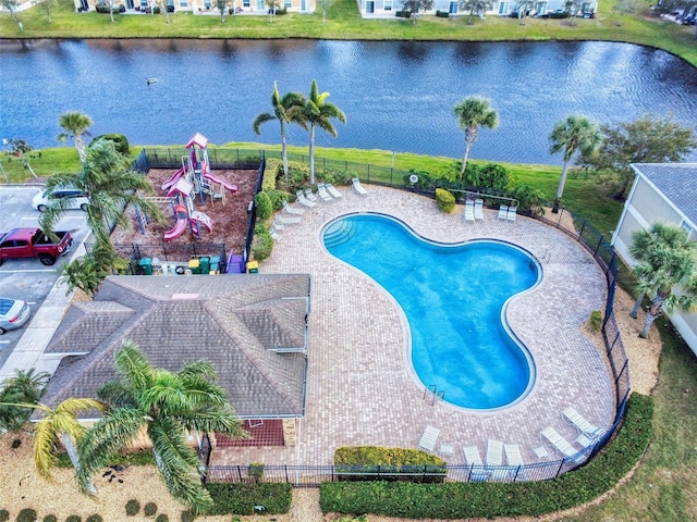 view of swimming pool featuring a patio area, a playground, and a water view