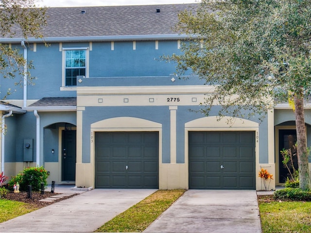 2775 Revolution St Unit 103, Melbourne, FL 32935 - multi unit property with stucco siding, roof with shingles, concrete driveway, and a garage