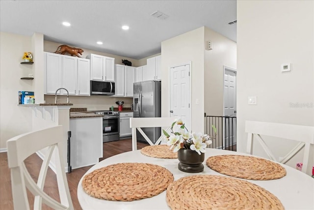 2775 Revolution St Unit 103, Melbourne, FL 32935 - kitchen featuring white cabinets, appliances with stainless steel finishes, visible vents, recessed lighting, and dark wood finished floors