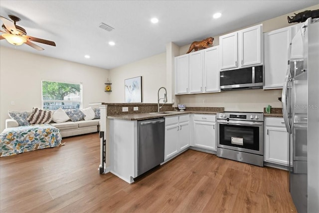 2775 Revolution St Unit 103, Melbourne, FL 32935 - kitchen featuring a sink, ceiling fan, stainless steel appliances, wood finished floors, and a peninsula