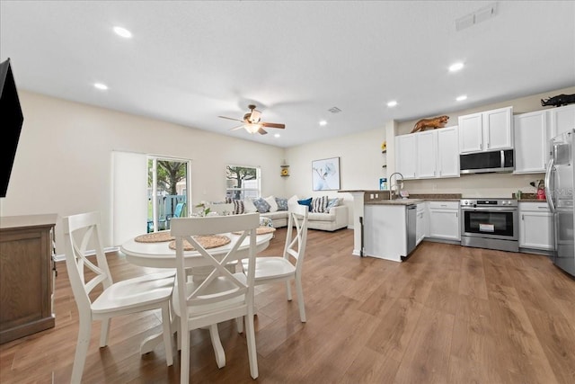 2775 Revolution St Unit 103, Melbourne, FL 32935 - kitchen with appliances with stainless steel finishes, a sink, a ceiling fan, a peninsula, and open floor plan