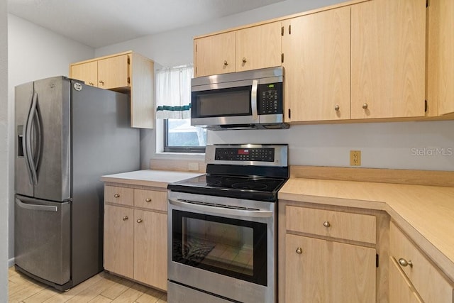 kitchen featuring light brown cabinets, appliances with stainless steel finishes, and light wood-type flooring