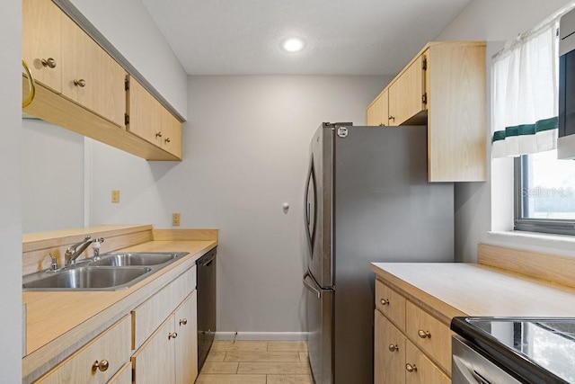 kitchen with sink, light brown cabinets, black dishwasher, and stainless steel refrigerator