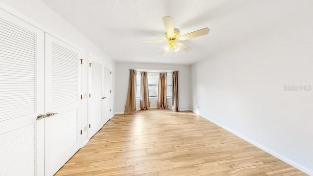 empty room with light wood-type flooring and ceiling fan