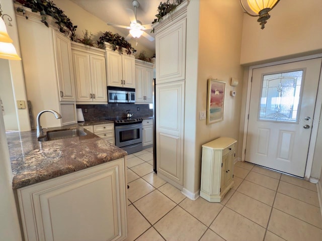 kitchen with sink, stainless steel appliances, light tile patterned floors, and backsplash