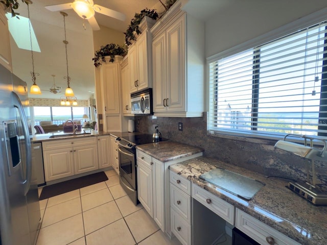 kitchen featuring decorative backsplash, light tile patterned floors, a wealth of natural light, and stainless steel appliances