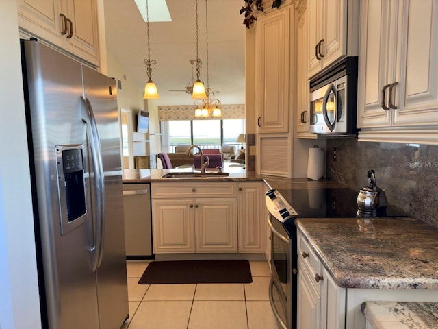 kitchen featuring appliances with stainless steel finishes, sink, decorative light fixtures, light tile patterned floors, and decorative backsplash