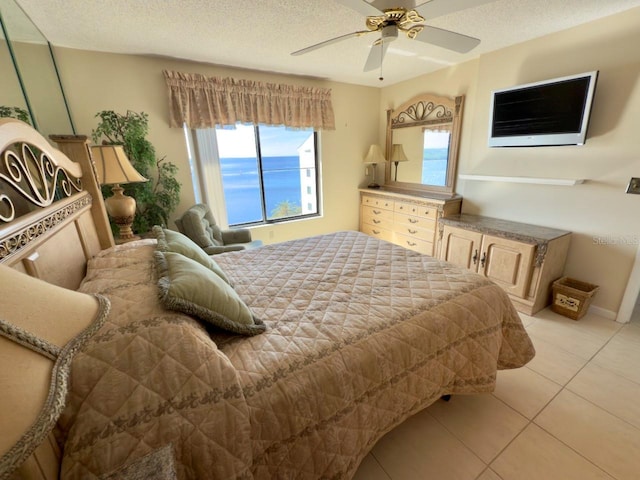 tiled bedroom featuring ceiling fan and a textured ceiling