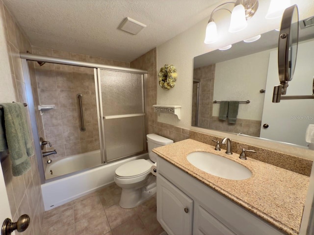 full bathroom with toilet, a textured ceiling, combined bath / shower with glass door, tile walls, and vanity