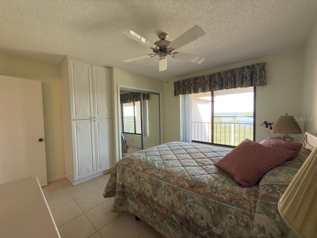 bedroom with light tile patterned flooring, a textured ceiling, a closet, and ceiling fan