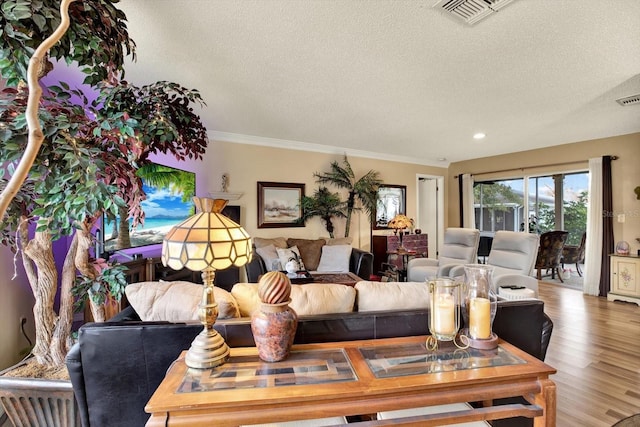 living room featuring hardwood / wood-style flooring, a textured ceiling, and crown molding