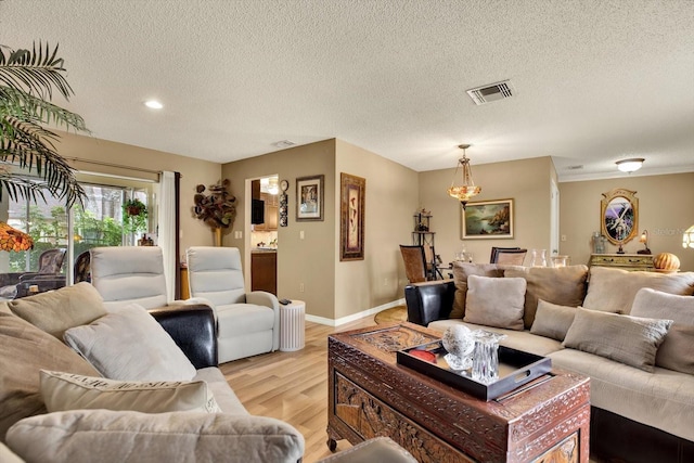 living room with a textured ceiling and light wood-type flooring