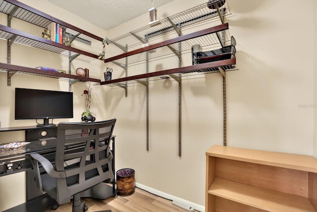 office area with a textured ceiling and light hardwood / wood-style flooring