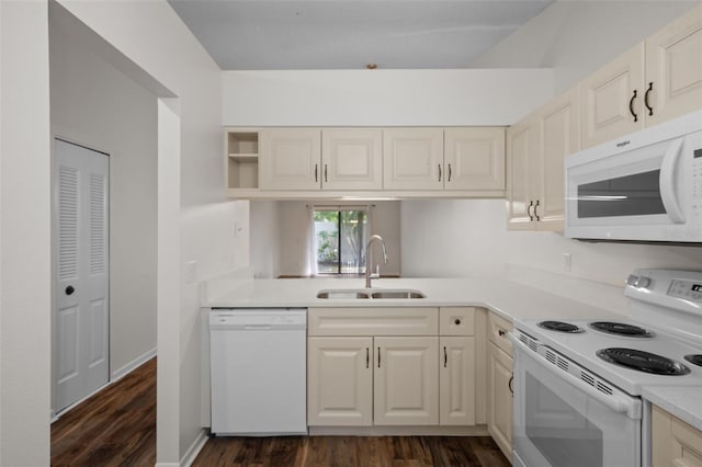 kitchen with sink, dark hardwood / wood-style floors, and white appliances