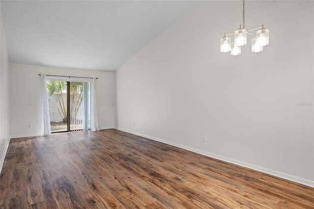 unfurnished room with vaulted ceiling, dark hardwood / wood-style flooring, and a chandelier