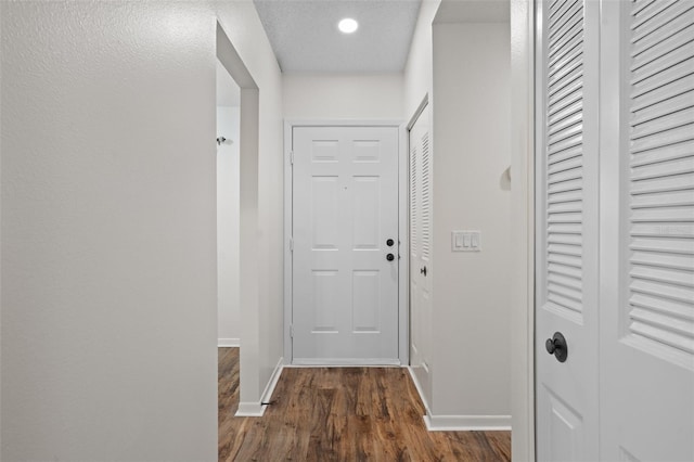 hallway with dark wood-type flooring and a textured ceiling