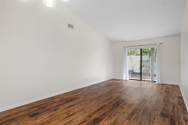 unfurnished room featuring vaulted ceiling and dark hardwood / wood-style flooring