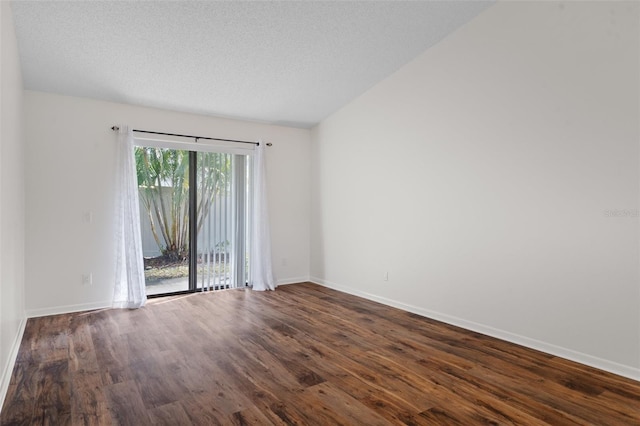 spare room with dark hardwood / wood-style floors and a textured ceiling