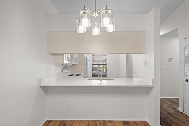 kitchen featuring decorative light fixtures, sink, white cabinetry, and white appliances