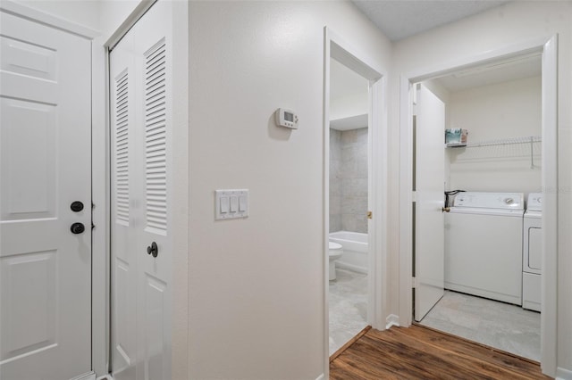 corridor featuring separate washer and dryer and hardwood / wood-style floors