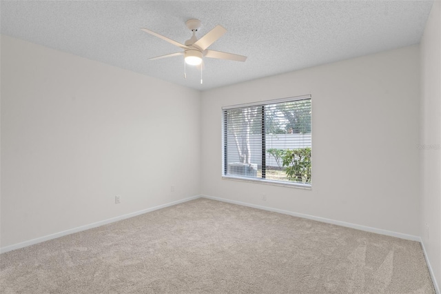 spare room featuring light carpet, ceiling fan, and a textured ceiling