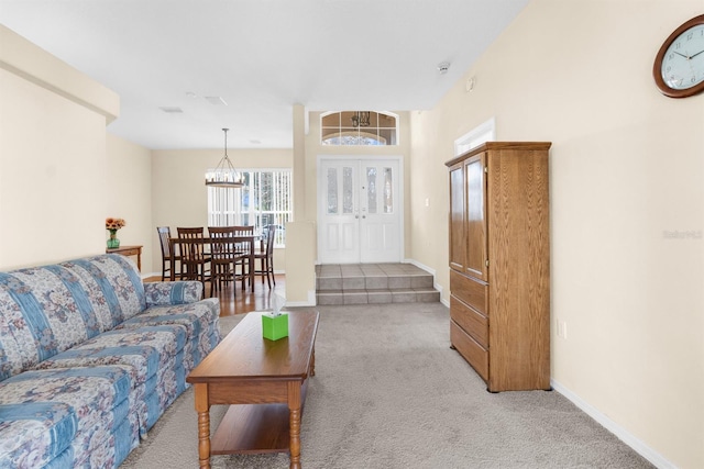 living room featuring light colored carpet and a chandelier