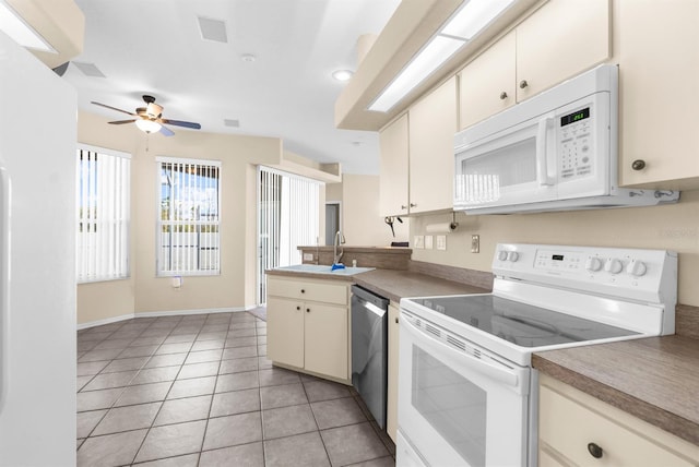 kitchen with sink, white appliances, ceiling fan, cream cabinets, and light tile patterned flooring