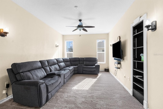 carpeted living room featuring ceiling fan and a textured ceiling