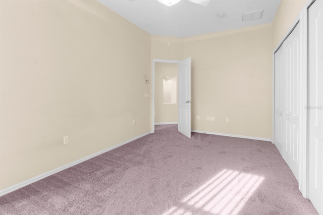 unfurnished bedroom with a closet and light carpet