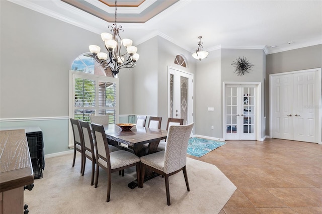 dining room with crown molding, light tile patterned flooring, a tray ceiling, and french doors