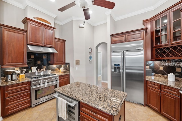 kitchen with backsplash, premium appliances, beverage cooler, and ornamental molding