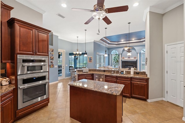 kitchen featuring hanging light fixtures, kitchen peninsula, light stone counters, and light tile patterned flooring