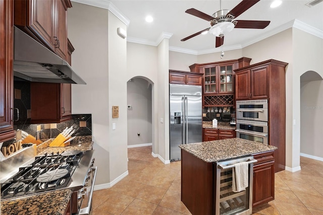 kitchen featuring appliances with stainless steel finishes, ornamental molding, dark stone counters, beverage cooler, and light tile patterned flooring