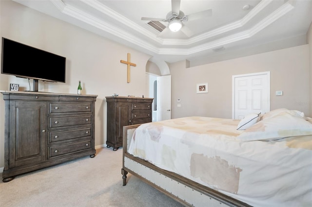 carpeted bedroom with ceiling fan, a raised ceiling, and crown molding